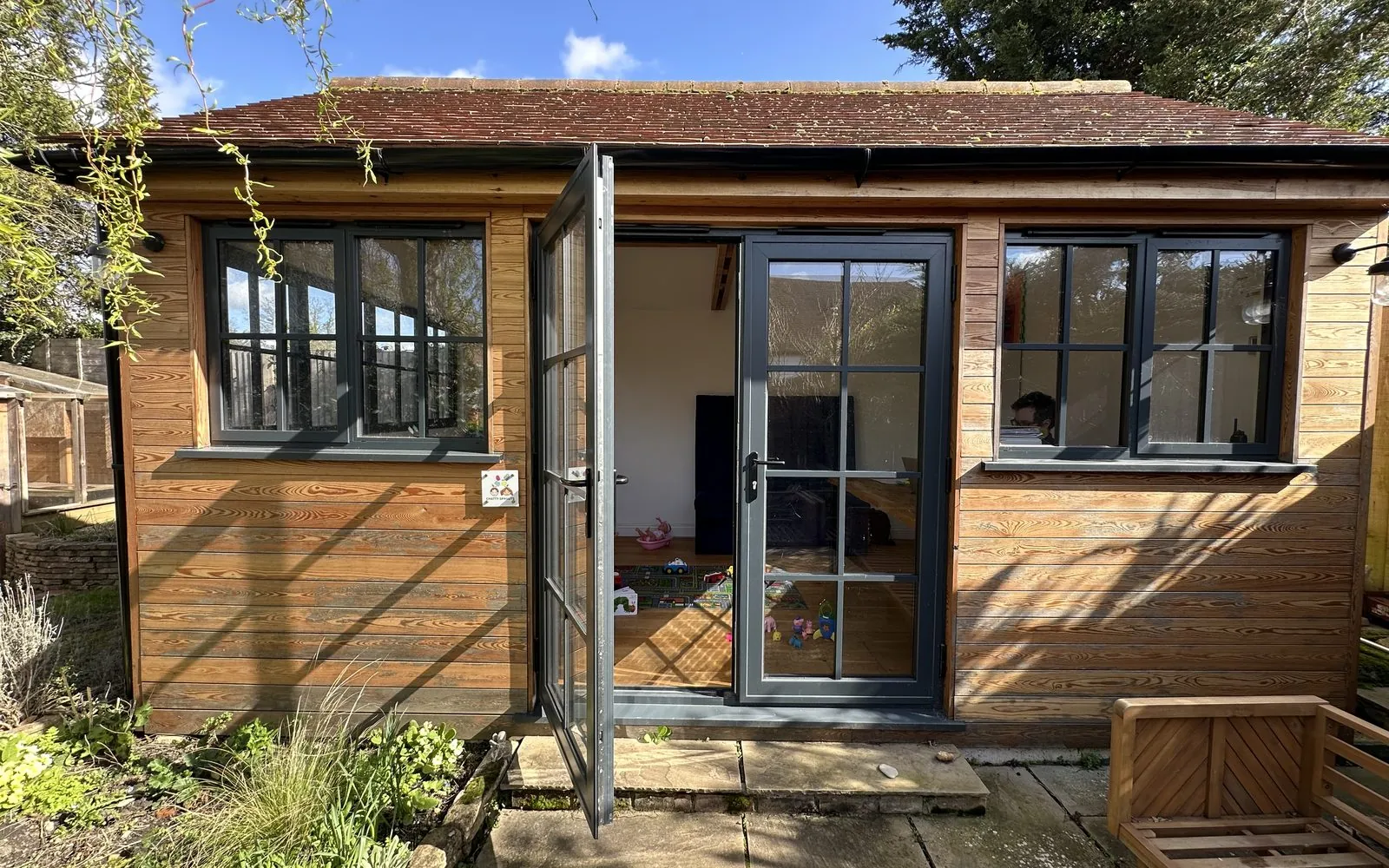 The Chatty Sprouts garden studio in Marden, Kent, with its doors open on a sunny day.