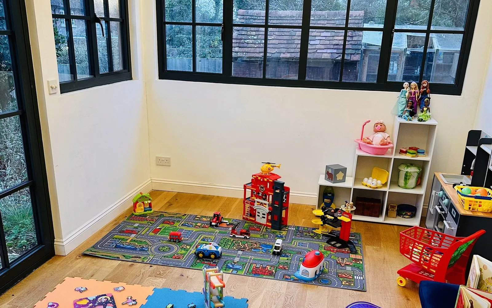 Toy kitchen, shelving and books in the corner of the therapy studio.