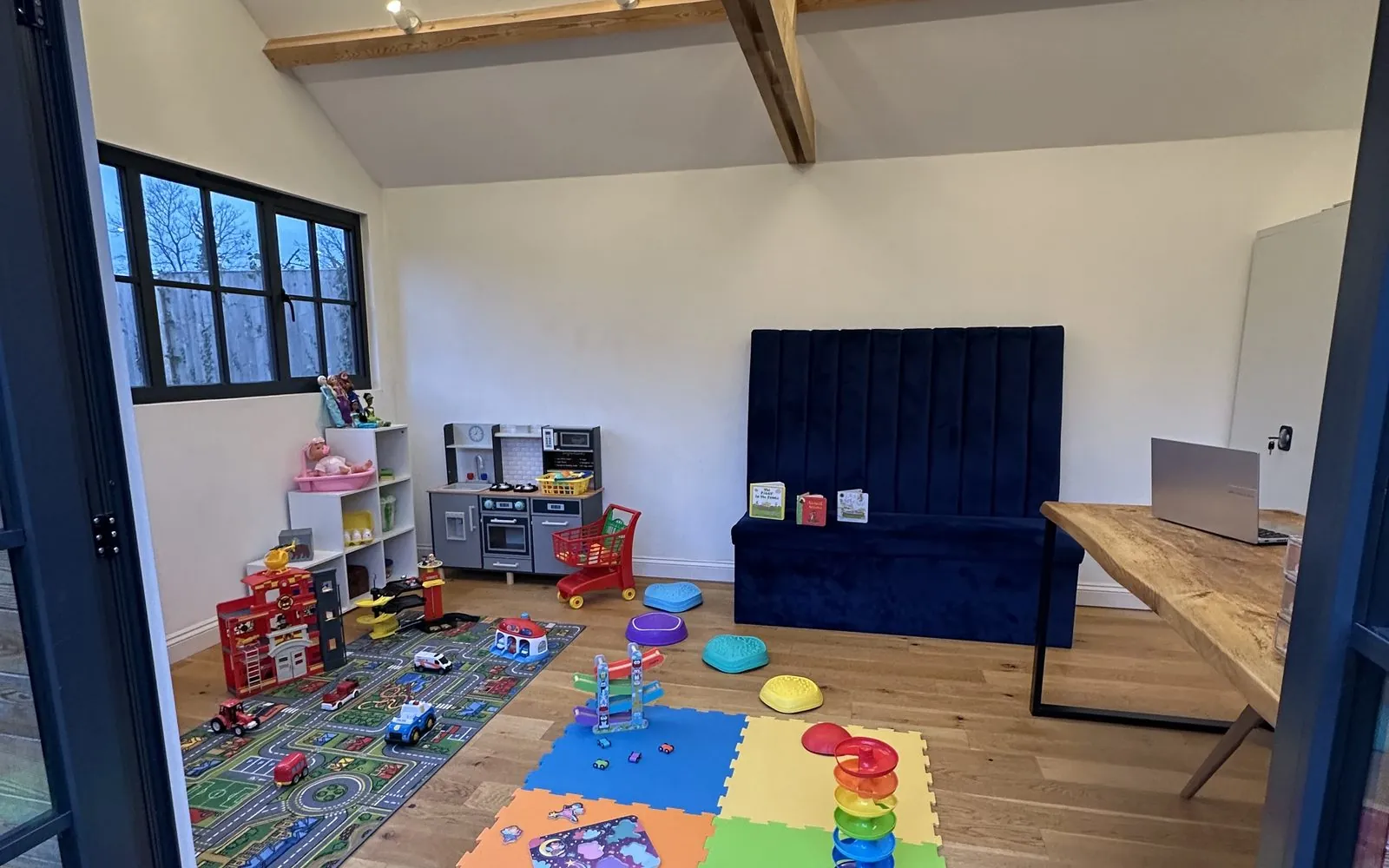 Looking into the Chatty Sprouts studio from the garden doors, with play mats and toys laid out ready.